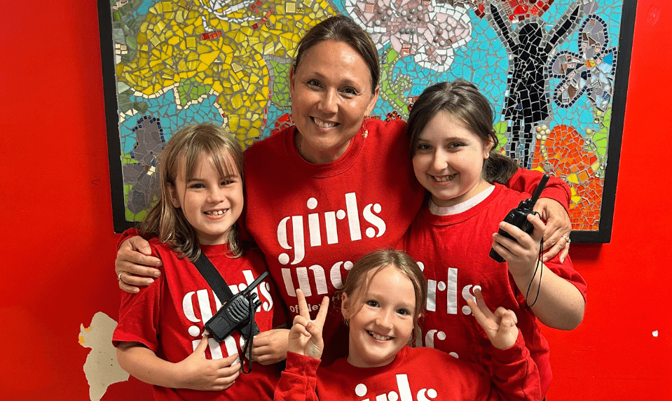 staff and three girls in red t-shirts